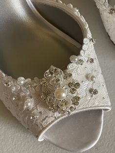 Gorgeous and comfortable Lace shoes heel is 2 1/2'' inches VERY ELEGANT AND MODERN color: Diamond white = Off-white, and also available in IVORY LACE floral trim edging the shoes, silver dots all over and a few scattered glass crystals and pearls over the front. US Sizes: M width (standard width) (I'm sold out of some sizes please look at sizes menu) US Sizes: 5, 5.5, 6, 6.5, 7, 8, 8.5, 9, 9.5, 10, 11 Outside USA, please goggle a US Size chart convertor before ordering or contact for help. FINAL White Rhinestone Shoe Clips, White Embellished High Heel, Embellished White High Heels, White Embellished High Heels, White Embellished Almond Toe Heels, White Crystal Embellished Shoe Clips For Wedding, White Embellished Closed Toe Heels, Elegant White Open Toe Wedding Shoes, White Embellished High Heel Wedding Shoes