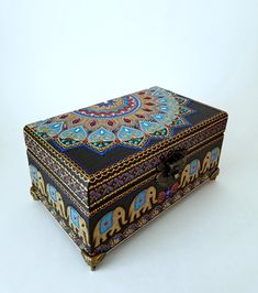 an ornately decorated box with elephants painted on it's sides and the lid