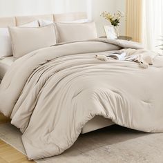 an unmade bed with white sheets and pillows on top of it in a room