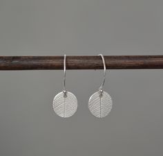 "Handmade sterling silver leaf oval disc hoop earrings. These simple and elegant earrings are perfect for any occasion or for gift giving. Total length from the top of the hoop: 2.2 cm (0.8\") Ovals: approximately 1 cm (0.3\") X 1.1 cm (0.4\") Circle wire : 1.6 cm (0.6\") x 1.3 cm (0.5\") They will come in a beautiful gift box." Silver Leaf-shaped Minimalist Earrings, Silver Leaf Minimalist Earrings, Minimalist Silver Leaf Earrings, Minimalist Sterling Silver Leaf-shaped Earrings, Minimalist Leaf-shaped Sterling Silver Earrings, Oval Stud Earrings, Leaf Charms, 925 Silver Jewelry, Sterling Silver Hoops