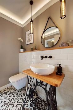 a bathroom with a sink, mirror and sewing machine on the counter in front of it