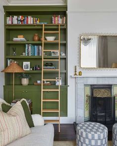 a living room with green bookshelves and a fire place in the corner next to a fireplace