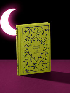 a yellow book sitting on top of a purple table next to a pink moon and black background