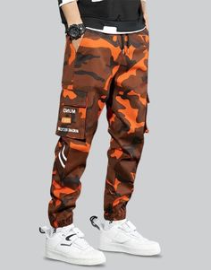 Orange Techwear Pants Stretch Cotton Techwear Parachute Pants, Stretch Cotton Parachute Pants In Techwear Style, Hip Hop Parachute Pants For Winter Outdoor, Stretch Techwear Parachute Pants, Camouflage Sweatpants With Pockets For Streetwear, Cotton Techwear Sweatpants For Outdoor, Cotton Techwear Cargo Pants For Sports, Stretch Cargo Pants For Winter Streetwear, Stretch Winter Cargo Pants For Streetwear