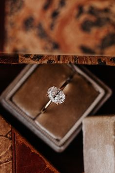 an engagement ring sitting on top of a book