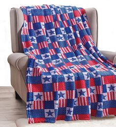 a red, white and blue blanket sitting on top of a chair next to a couch