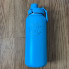 a blue water bottle sitting on top of a wooden floor