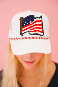 a woman wearing a white hat with an american flag patch on the front and side