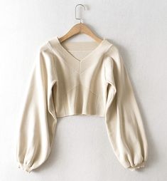 The Cream Balloon Sleeve Knit Sweater is a stylish addition to any wardrobe, offering a blend of comfort and contemporary fashion. This sweater features an elegant V-neckline and unique geometric ribbed detailing on the front, adding a touch of sophistication to its casual appeal. The soft cream color makes it versatile and easy to pair with a variety of outfits, whether youre dressing up for a day out or keeping it cozy at home.Crafted from high-quality knit fabric, this sweater ensures a comfo Solid Ribbed V-neck Knit Top, Fitted Textured Knit V-neck Sweater For Winter, Chic Ribbed Cropped Sweater For Fall, Beige Knitted V-neck Cardigan, Stretch Ribbed V-neck Sweater, Beige Knit V-neck Sweater For Fall, Beige Knit V-neck Cardigan, Elegant Long Sleeve V-neck Sweater For Winter, Elegant V-neck Long Sleeve Top For Winter