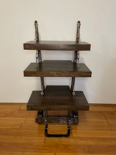 a three tiered wooden shelf on top of a hard wood floor