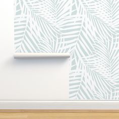 a white and blue wallpaper with palm leaves on it in the corner of a room