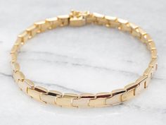 "This timeless link bracelet is the perfect accessory for any occasion. Crafted from 18-karat yellow gold, its sophisticated links add an elegant touch to your ensemble. Show off your style and sophistication with this classic piece. Metal: 18K Yellow Gold Width: 6.5 mm Length: 7 3/4 Inches Marks: \"<750>\" Stamped on the clasp To view a video of this piece check out the link below: https://vimeo.com/846390865 SKU #: A29511 Each piece has been identified and graded by a Graduate Gemologist who has been certified by the Gemological Institute of America (GIA). We have six brick-and-mortar storefronts in Maine, Massachusetts, and New Hampshire and have been in business for over 25 years! Please visit our Shop's About Page or our website for more information about our jewelry. For questions ab Jewelry Layering, Gold Link Bracelet, Gold Armband, Pocket Watch Chain, Gold Link, Yellow Gold Jewelry, Yellow Gold Bracelet, Layered Bracelets, Pearl Pendant