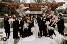 a group of people standing around each other in front of a gazebo with feathers on it