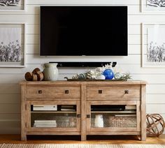 a flat screen tv mounted to the side of a wooden cabinet in a living room