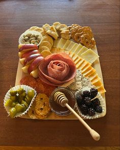 a wooden table topped with lots of different types of cheese and crackers on top of it