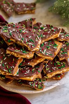 a plate full of chocolate and sprinkles on top of a table next to a christmas tree