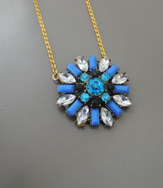 "Vintage Jewelry- Vintage Inspired Necklace - Crystal Necklace - Flower Necklace - Blue Necklace - Pendant Necklace - Gold Necklace This is such a pretty vintage inspired necklace! A geometric floral design embellished with sparkling shades of blue and clear crystals set in a gold plated setting. The pendant hangs from a gold plated rolo chain. Chloe says, \"Wear it and feel fabulous!\" The pendant measures 1 1/2\" round. You can choose the necklace length you would like at checkout. Thanks for Vintage Blue Pendant Necklace, Vintage Blue Flower Pendant Jewelry, Handmade Blue Flower Pendant Necklace, Vintage Blue Jeweled Necklaces, Blue Pendant Necklaces With Flower Charm, Blue Pendant Necklace With Flower Charm, Vintage Blue Flower Pendant Necklace, Elegant Blue Flower Pendant Necklace, Vintage Blue Jewelry With Flower Charm