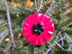 a red ornament hanging from a christmas tree