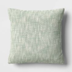 a green and white pillow sitting on top of a table