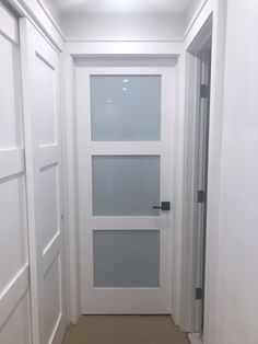 an empty hallway with white walls and doors