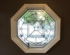 a round stained glass window mounted to the side of a wall