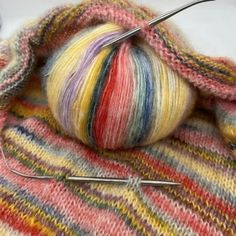 a ball of yarn is sitting on top of some knitting needles