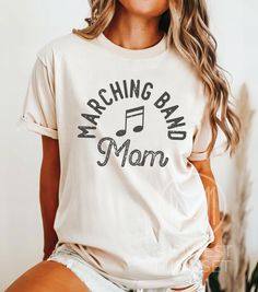 Marching Band Shirt, Band Mom Shirt, High School Band Tshirt, Marching Band Gift, Halftime Show TShirt, Drumline Shirt, Music Mom Tee Comfort Colors 1717:  T-Shirt Sizing The Comfort Colors 1717 is a relaxed fit shirt.  Please reference the size chart before selecting shirt size.  To achieve an oversized t-shirt dress look, we recommend sizing up two sizes. T-Shirt Materials: -  100% ring-spun cotton with a medium fabric. -  Soft-wash feel. -  Pre-shrunk fabric for size retention. -  Crew neck l Relaxed Fit Band Logo Tops For Music Festivals, Cotton Shirt With Band Logo Fan Merchandise, Cotton Shirt With Band Logo For Fan Merchandise, Music-themed Band Logo Tops With Short Sleeves, Spring Band Merch Tops With Band Logo, Spring Band Logo Merch Tops, Music-themed Cotton Top With Text Print, Music-themed Cotton Shirt Fan Merchandise, Music-themed Screen Print Top For Concerts