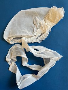 Made from a fine feather-light sheer white cotton, this beautiful bonnet is in virtually pristine condition. Sized for a child's or a young adult's head. The circumference along the inner edge is measure at around 22" (because of how the bonnet would be worn, with the back section at the base of the head, this is not equivalent to a typical hat circumference). The wide long ties are 22" in length. A combination of machine-sewing and hand-sewing. The delicate scalloped edges on the ruffled sectio White Fitted Vintage Bonnet, White Vintage Bonnet For Summer, Vintage White Adjustable Bonnet, White Adjustable Vintage Bonnet, Period Clothing, Elastic Thread, Machine Sewing, Handmade Hat, Feather Light