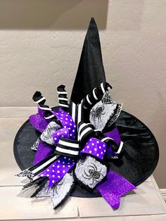 a witches hat with purple and black ribbons