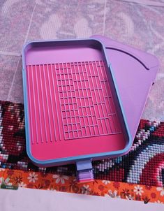 a pink and blue grill sitting on top of a rug