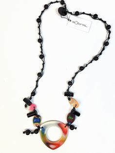 This necklace is part of the retired Tropicalia line and is called Taiza. This necklace features a tropical colored main pendant with 3 small dangling pendants on a black cord of hand knotted black and blue beads. The length is 30" not including the pendants.  The first United Nations Conference to address environmental degradation was held in Stockholm in 1972. Already at that time the designer Carlos Sobral was working with resin and creating new techniques and alternative products to reuse al Sobral Jewelry, Environmental Degradation, Winston Salem Nc, Winston Salem, Earring Cards, Reddish Brown, United Nations, Fabric Jewelry, Blue Beads