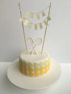 a cake with two tennis racquets on top and bunting flags above it