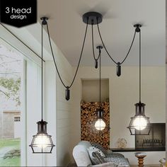 three lights hanging from the ceiling in a living room with wood stacked on the wall