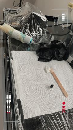 an object is being made on top of a table with plastic wrap and other items