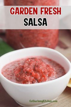 a white bowl filled with salsa next to a lemon wedge