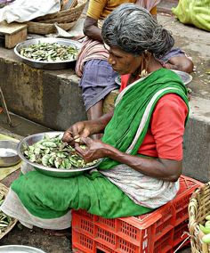 a woman sitting on the ground with food in front of her