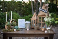 a wooden table topped with lots of different types of decorations and candles on top of it