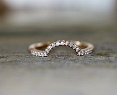 a close up view of a diamond ring on a wooden surface with blurry background