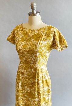 "1950s cotton sateen very fitted day dress. Ivory ground with an all over mustard brush stroke floral print. The neckline is pointed scallops. Top-stitched seams across the bodice, as well as form fitting vertical seams front and back. Cap sleeves, a V-back, with a metal zipper and hook and eye closure. Size- Small Bust - 34\" Waist - 27\" Hips - 39\" Length - 39\" Label: Janice Jr. Condition: Excellent vintage condition. All vintage is sold in \"as-is\" condition. We do our best to inspect, cor Yellow Fitted Dress In 1950s Style, Fitted Yellow Dress In 1950s Style, Mustard Fitted Cotton Dress, Fitted Mustard Cotton Dress, Mustard Fitted Floral Print Dress, Fitted Mustard Floral Print Dress, Fitted Yellow 1950s Dresses, Fitted Vintage Mustard Dress, Fitted Mid-century Yellow Dress