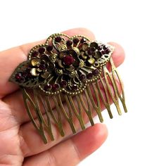 Capturing the elegance of the Victorian Renaissance era this stunning brass filigree deep red bling hair comb with a unique character is perfect for a stylish antique look for any special dress occasion or just to complement your unique style. A gorgeous hair adornment will add a touch of timeless vintage glamour to any outfit. A perfect Christmas or Valentine's romantic gift idea for her. This sophisticated exotic nature-inspired floral hair accessory features antique brass combs accented with hand-formed flower settings and handset dark red glass crystal rhinestones with antique brass delicate leaves on both sides surrounded by matching color multiple tiny crystal rhinestone beads. The comb is just over 2" (5.2 cm) long and 2.1" (5 5 cm) tall. The teeth of the comb measure 3 cm in length Vintage Hair Jewelry, Victorian Era Accessories, Bling Hair, Vintage Hair Comb, Victorian Hair, Bridal Floral Headpiece, Victorian Accessories, Glamour Vintage, Special Dress