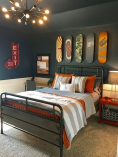 a bed room with a neatly made bed and skateboards on the wall