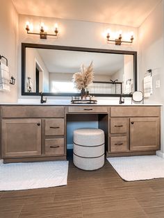 a bathroom with a large mirror, vanity and stools in it's center