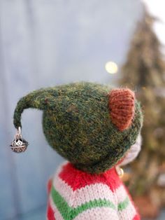 a small stuffed animal wearing a sweater and earring