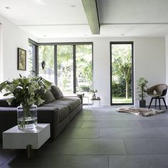 a living room filled with furniture and lots of windows next to a tv mounted on a wall