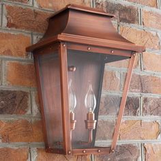 a wall mounted light on the side of a brick building