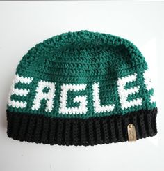 a green and white knitted hat with the word sale on it