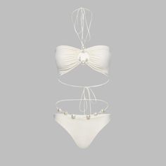 Make a bold and elegant statement with our Pearl Elegance Cutout Bikini Set. This stunning swimsuit, available in classic black and milky white, is designed to turn heads with its unique and sophisticated style. The bandeau top features an eye-catching cutout design adorned with chic pearl accents, adding a touch of luxury to your beachwear. The matching high-cut briefs are detailed with pearl-accented straps, ensuring you look fabulous from every angle. Crafted from a high-quality blend of nylo Elegant Bandeau Halter Top For Beach, Elegant White Swimwear For Sunbathing, White Triangle Halter Top For Party, Elegant White Swimwear For Beach Season, Elegant White Swimwear For Poolside, Elegant Halter Top For Pool And Beach Season, Elegant White Halter Top For Vacation, Elegant Beachwear Halter Top, White Bandeau Swimwear For Pool