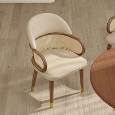 two white chairs sitting next to each other on top of a hard wood flooring