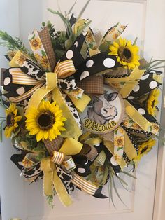 a yellow and black wreath with sunflowers on the front door for someone's house