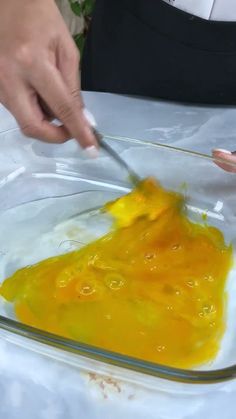 a person is cutting something yellow with a knife